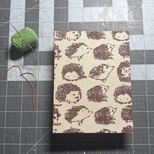 Brown hedgehogs on cream background. Hand Sewn Notebook Made in Alaska
